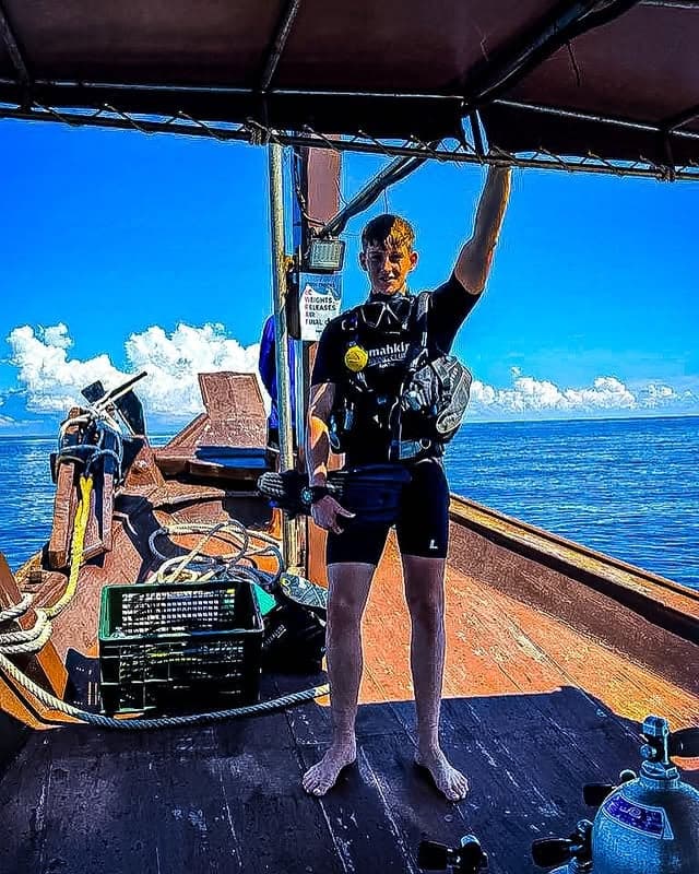 Zac in scuba gear on the deck of a dive boat in Thailand